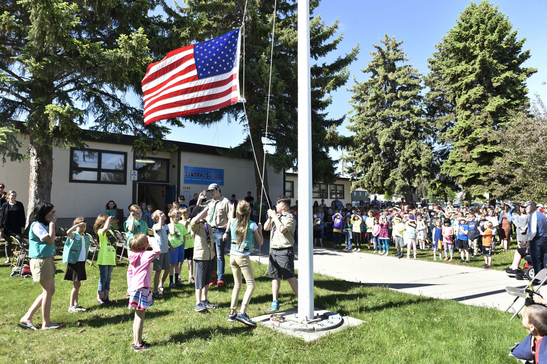 Group of Girl Scout and Boy Scouts lower the American Flag